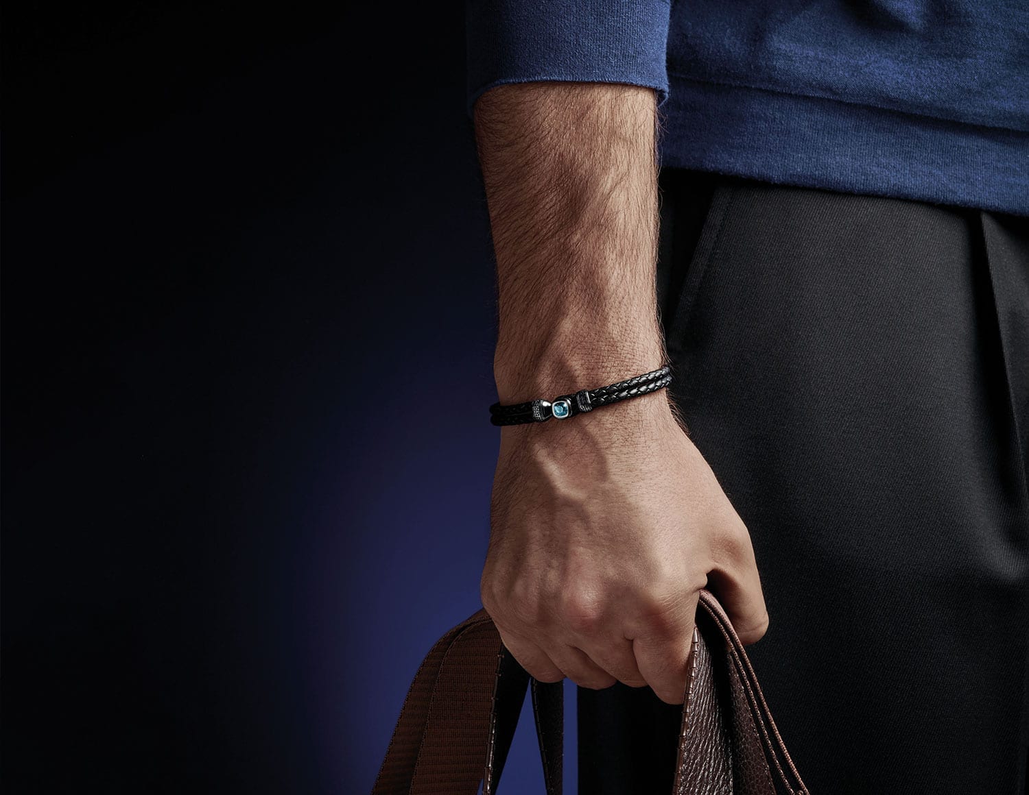 Schwarzes MAGIOR Lederarmband mit Aquamarin-Schließe am Handgelenk eines Mannes